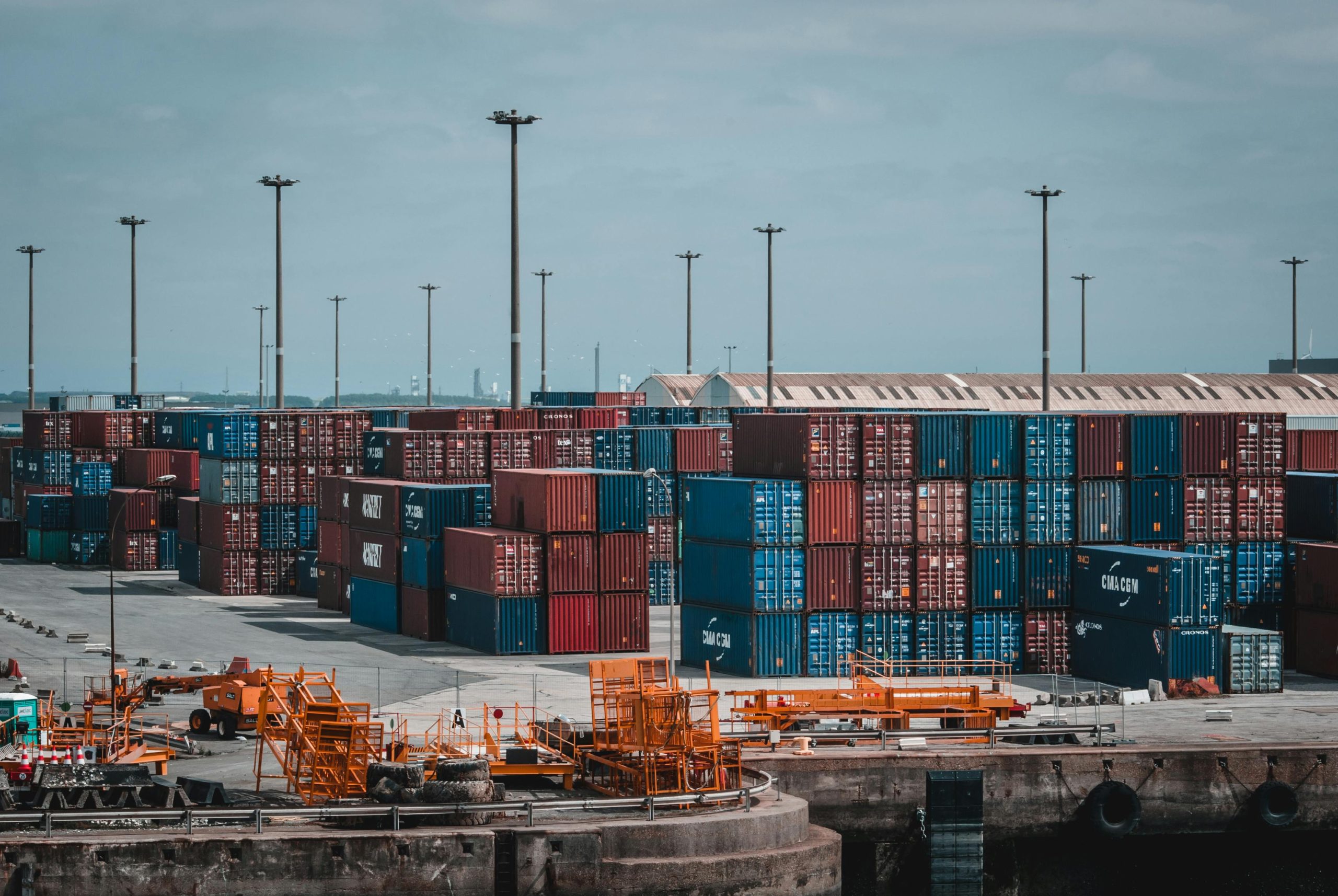 Services Colorful cargo containers stacked at a busy industrial port, showcasing global trade.